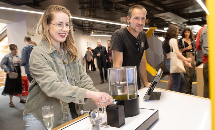 Two adults work the Design a Water Drop exhibit at one of Techniquest's Adult Lates event.